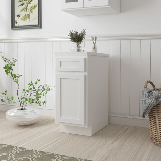 15-inch white single vanity base cabinet with drawer and door, angled view in bright laundry room