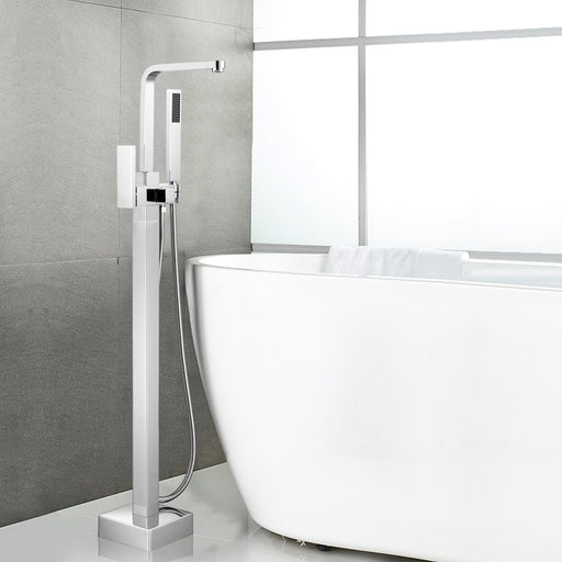 HomeBeyond chrome freestanding tub faucet beside large oval white bathtub against light gray wall with window